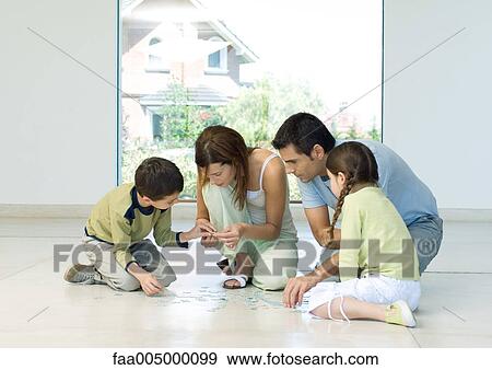 Stock Photo - Family putting together puzzle. Fotosearch