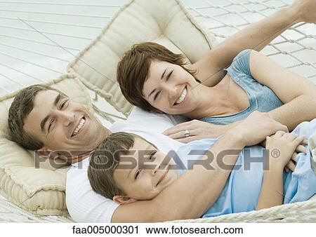 Stock Image - Family relaxing in hammock. Fotosearch