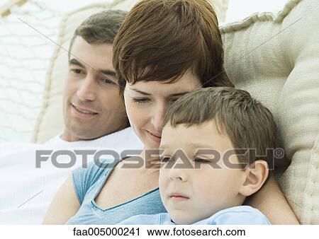 Stock Image - Family relaxing in hammock together, close-up. Fotosearch