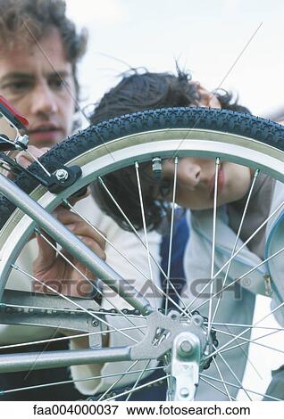 Father and son fixing bike View Large Photo Image Stock Photo - Father and son fixing bike. Fotosearch