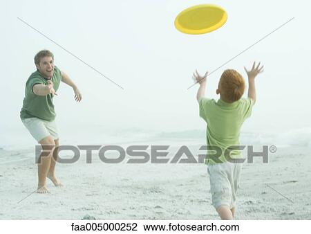 Father and son throwing frisbee on beach View Large Photo Image Stock Image - Father and son throwing frisbee on beach. Fotosearch