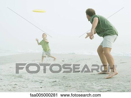 Father and son throwing frisbee on beach View Large Photo Image Stock Image - Father and son throwing frisbee on beach. Fotosearch