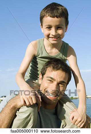 Father carrying son on shoulders View Large Photo Image Stock Image - Father carrying son on shoulders. Fotosearch