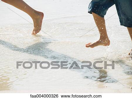 Feet running through surf View Large Photo Image Stock Photograph - Feet running through surf. Fotosearch
