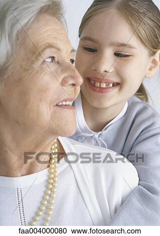 Girl and grandmother smiling at each other View Large Photo Image Stock Image - Girl and grandmother smiling at each other. Fotosearch