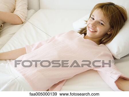 Stock Photo - Girl reclining on sofa. Fotosearch
