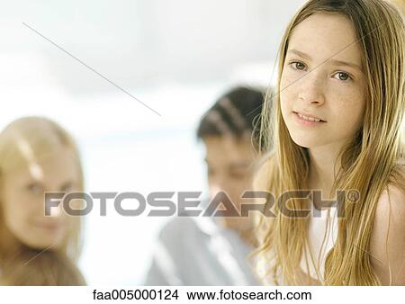 Girl with parents in background, portrait View Large Photo Image Picture - Girl with parents in background, portrait. Fotosearch