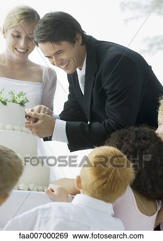 Groom cutting wedding cake View Large Photo Image Stock Photo - Groom cutting wedding cake. Fotosearch