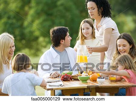 Stock Photo - Group having breakfast outdoors. Fotosearch