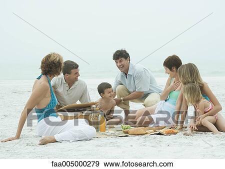 Stock Photo - Group having picnic on the beach. Fotosearch