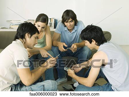Group of young adult friends looking at photos View Large Photo Image Stock Image - Group of young adult friends looking at photos. Fotosearch