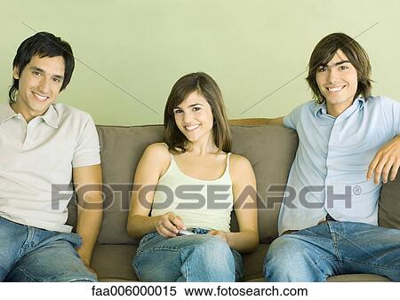 Group of young adult friends sitting on sofa View Large Photo Image Stock Photography - Group of young adult friends sitting on sofa. Fotosearch