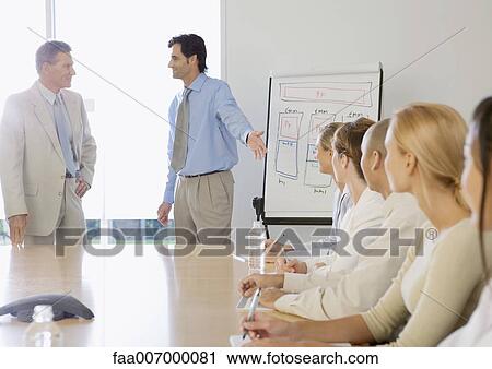 In boardroom, businessman introducing ceo to business team View Large Photo Image Stock Image - In boardroom, businessman introducing ceo to business team. Fotosearch