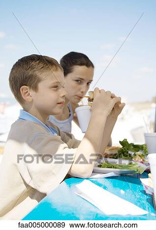 Stock Photo - Kids eating outdoors. Fotosearch