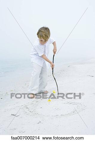 Little boy drawing heart in the sand at the beach View Large Photo Image Picture - Little boy drawing heart in the sand at the beach. Fotosearch