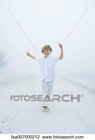 Little boy running on beach, flowers in hands View Large Photo Image Stock Image - Little boy running on beach, flowers in hands. Fotosearch