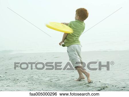 Stock Photograph - Little boy throwing frisbee. Fotosearch
