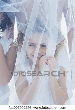 Little girl standing underneath bride's veil View Large Photo Image Stock Photograph - Little girl standing underneath bride's veil. Fotosearch