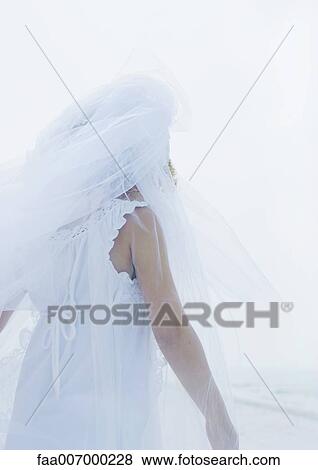 Stock Photo - Little girl wearing bridal veil, rear view. Fotosearch