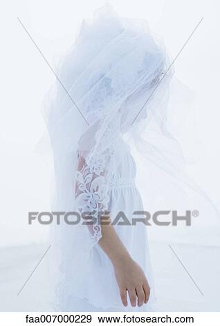 Stock Photo - Little girl wearing bridal veil, side view. Fotosearch