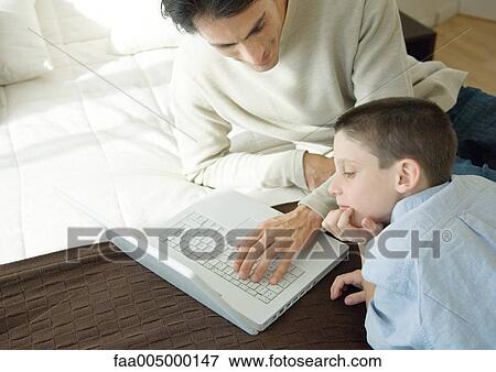 Man and son using laptop View Large Photo Image Stock Photo - Man and son using laptop. Fotosearch