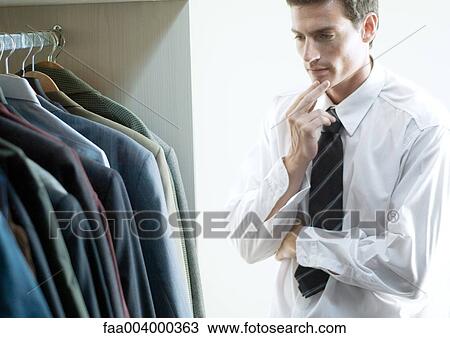 Man choosing jacket from closet View Large Photo Image Stock Image - Man choosing jacket from closet. Fotosearch