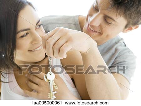 Stock Image - Man handing woman keys. Fotosearch