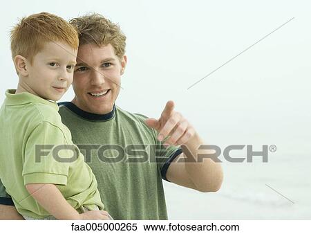 Stock Photography - Man holding son, pointing. Fotosearch