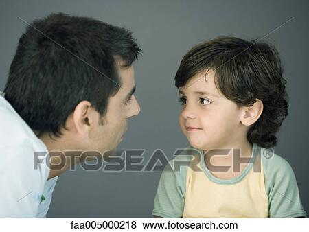 Stock Photo - Man looking at son, close-up. Fotosearch