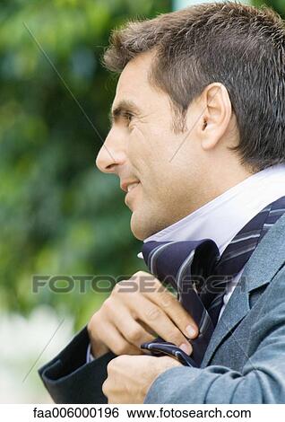 Man putting on tie View Large Photo Image Stock Photograph - Man putting on tie. Fotosearch