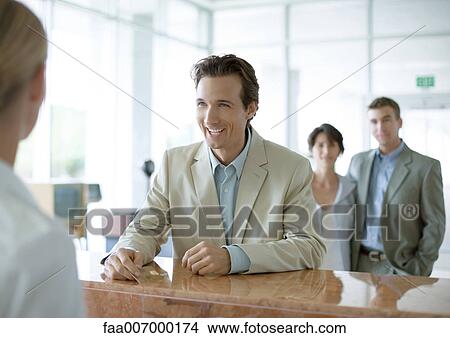 Man standing at reception desk View Large Photo Image Picture - Man standing at reception desk. Fotosearch