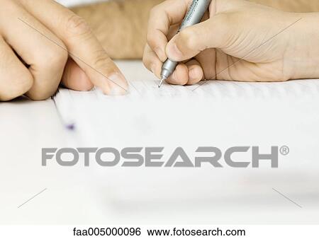 Stock Photograph - Man's finger pointing to page while child writes, extreme close-up. Fotosearch
