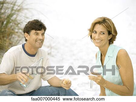 Mature couple drinking water from wine glass on beach View Large Photo Image Stock Photography - Mature couple drinking water from wine glass on beach. Fotosearch