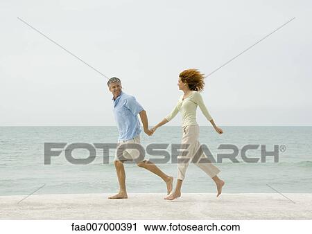 Mature couple running on beach View Large Photo Image Stock Image - Mature couple running on beach. Fotosearch