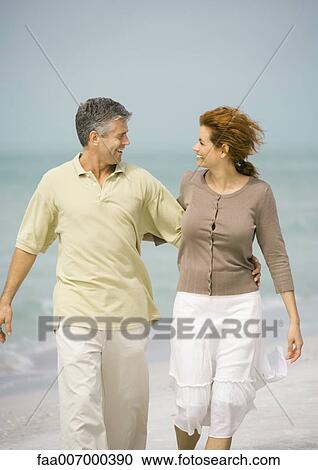 Mature couple walking on beach View Large Photo Image Stock Image - Mature couple walking on beach. Fotosearch