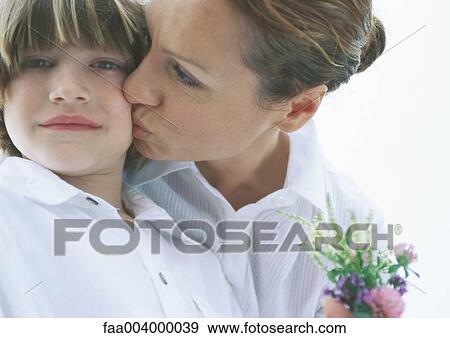 Mother with small bouquet of flowers kissing son on cheek View Large Photo Image Stock Photo - Mother with small bouquet of flowers kissing son on cheek. Fotosearch