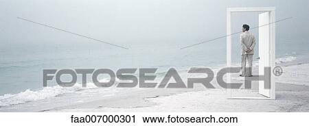 On beach, man seen through open doorway, looking at view View Large Photo Image Stock Image - On beach, man seen through open doorway, looking at view. Fotosearch