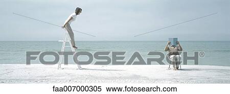On beach, woman standing on ladder shouting at man who sits, covering face View Large Photo Image Stock Photography - On beach, woman standing on ladder shouting at man who sits, covering face. Fotosearch