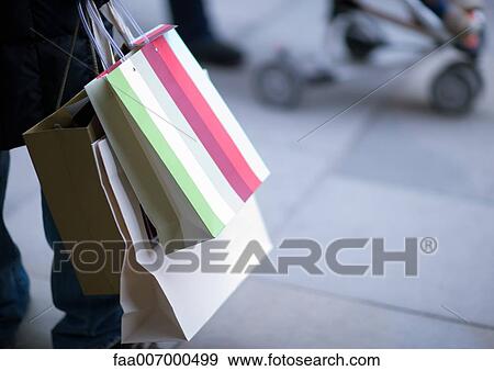 Person carrying shopping bags View Large Photo Image Stock Photo - Person carrying shopping bags. Fotosearch
