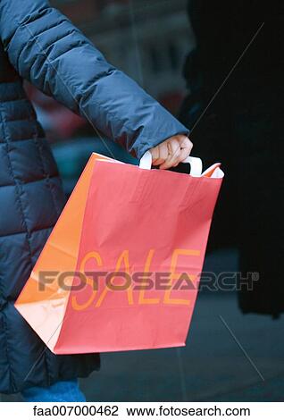 Person holding out shopping bag with "sale" printed on side View Large Photo Image Stock Image - Person holding out shopping bag with "sale" printed on side. Fotosearch