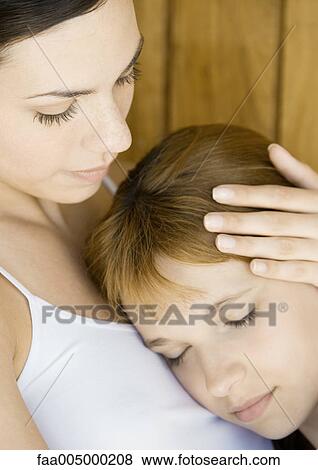 Preteen girl resting head on young woman's chest View Large Photo Image Stock Photo - Preteen girl resting head on young woman's chest. Fotosearch