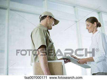 Stock Image - Receptionist sigining for delivery. Fotosearch