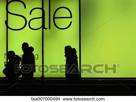 Sale sign in shop window and silhouettes of passers-by View Large Photo Image Picture - Sale sign in shop window and silhouettes of passers-by. Fotosearch