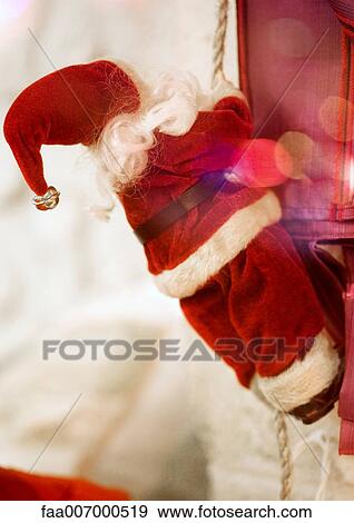 Stock Photo - Santa Claus doll climbing rope. Fotosearch