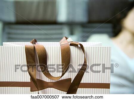 Shopping bag, person sitting in background View Large Photo Image Stock Photo - Shopping bag, person sitting in background. Fotosearch