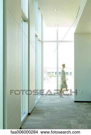 Silhouette of businesswoman walking by at end of corridor View Large Photo Image Picture - Silhouette of businesswoman walking by at end of corridor. Fotosearch