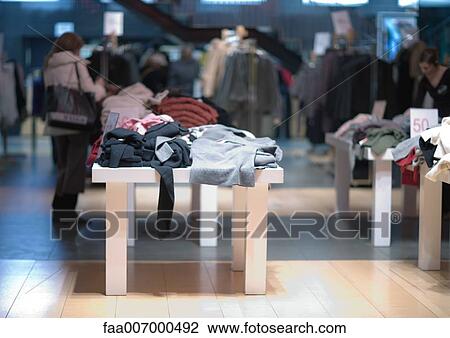 Tables full of clothes in shop View Large Photo Image Stock Image - Tables full of clothes in shop. Fotosearch