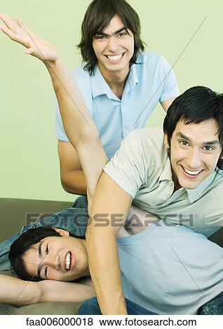 Three young men horsing around View Large Photo Image Stock Photo - Three young men horsing around. Fotosearch