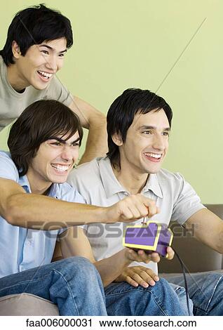 Three young men playing video games View Large Photo Image Stock Image - Three young men playing video games. Fotosearch