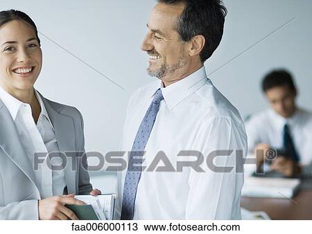 Stock Image - Two business colleagues smiling. Fotosearch